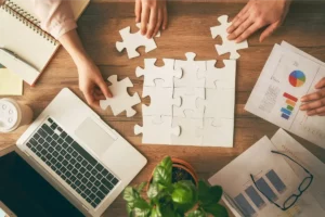 Strategic Succession Planning - Coworkers putting a paper puzzle together on their desk